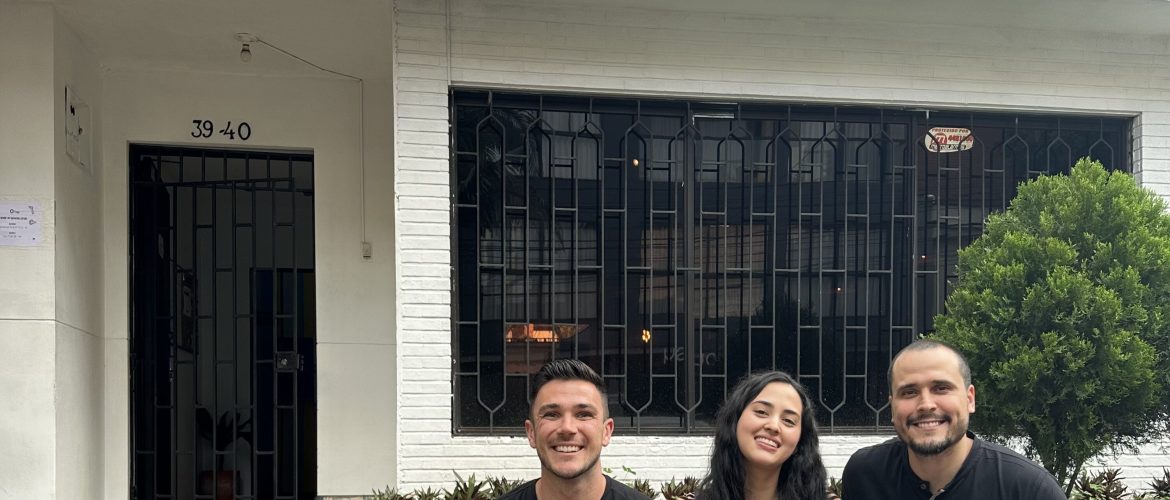 three people sitting in front of Spanish school